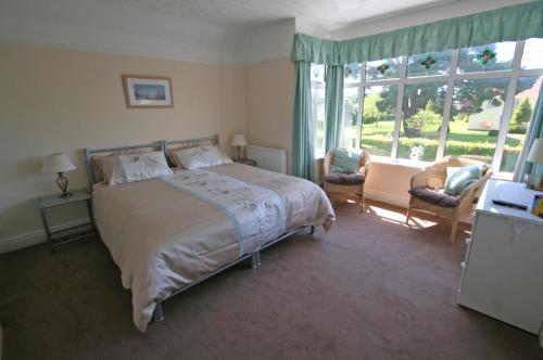 新米尔顿Beech Lodge Guest House的一间卧室设有一张床和一个大窗户