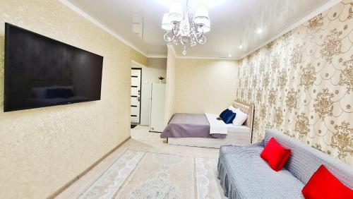 塔拉兹Абсолютно новая квартира класса ЛЮКС的卧室配有一张床,墙上配有电视。