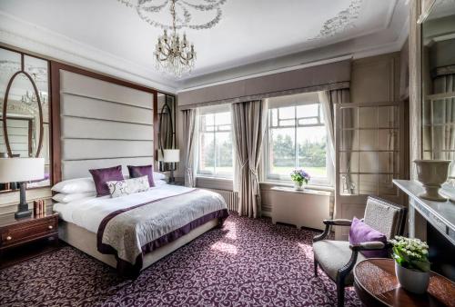 科巴姆伍德兰公园酒店的一间卧室配有一张床和一个吊灯