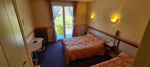 PolminhacLe VAL du CANTAL的酒店客房设有两张床和窗户。