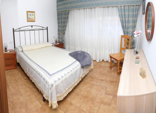 维拉加尔西亚·德·阿劳萨A Rosaleda的一间卧室配有一张床、一张桌子和一个窗户。