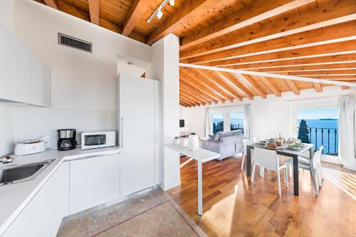 加尔多内-里维耶拉Poggio di Fasano 9 Apartment by Wonderful Italy的厨房以及带桌椅的用餐室。