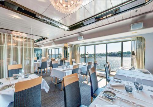 斯德哥尔摩Viking Line ferry Gabriella - Cruise Stockholm-Helsinki-Stockholm的餐厅设有白色的桌椅和大窗户