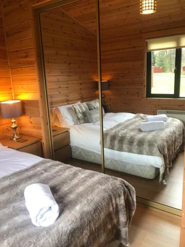 罗厄德南Lomond Lodge的小木屋内一间卧室,配有两张床