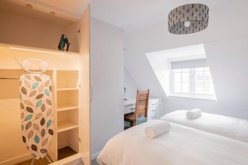 布莱顿霍夫3-bedroom apartment in the heart of Brighton's Lanes的一间白色卧室,配有两张床和窗户