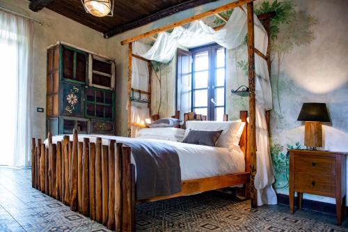 波佐利Masseria del Carmine Maggiore 1817的一间卧室设有木制天蓬床和窗户。