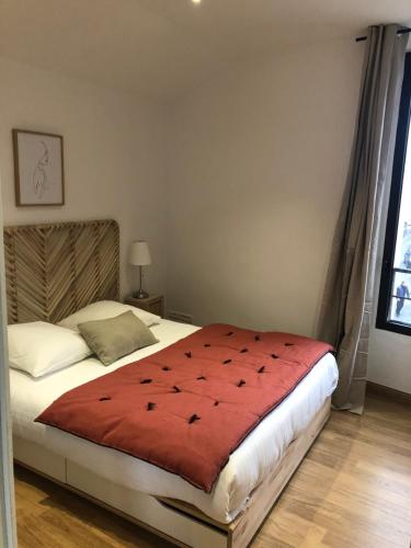 阿尔勒Entre les Arènes et la Major的一间卧室配有一张红色棉被的床