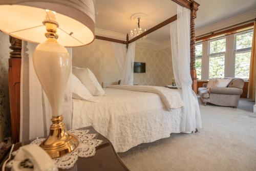 阿赫纳欣勒吉湾小屋酒店的一间卧室配有一张床和一张桌子上的台灯