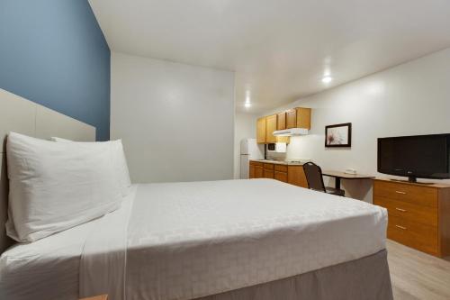 休斯顿休斯敦韦斯特彻斯伍德斯普林套房酒店的卧室配有白色的床和电视。