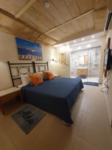Hal GhaxiakB&S Accommodation Apartment 601的一间卧室配有蓝色的床和橙色枕头