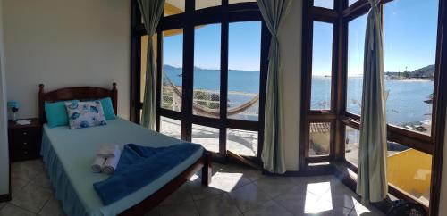 南圣弗朗西斯科Pousada Pedra das Tartarugas的一间卧室配有一张床,享有海景