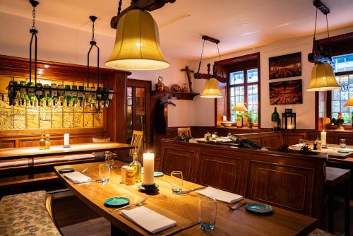 莱茵河畔威尔Ott's Hotel Weinwirtschaft & Biergarten Weil am Rhein/Basel的一间带木桌的餐厅和一间酒吧
