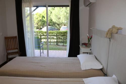 阿尔马达Apartamento, praia, golfe, Lisboa piscina publica com terifa的一间卧室设有一张床和一个滑动玻璃门