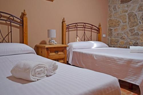LubiánLa Casa de Irene的一间卧室配有两张带白色床单的床