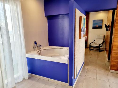 科尼尔-德拉弗龙特拉阿雷西费萨尔瓦多公寓的一间蓝色的浴室,内设浴缸