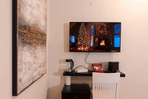 海法Golden Suite Bahai's Garden的一间设有一张桌子的房间,墙上有一台电视机