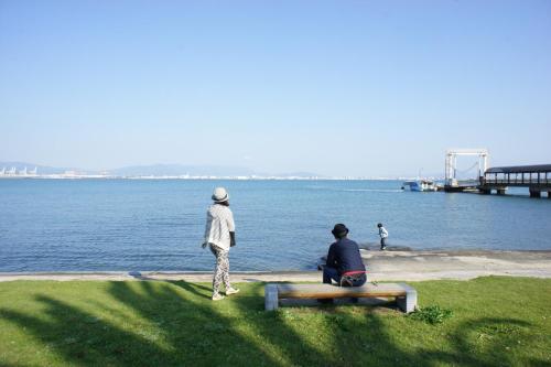 福冈Fukuoka - House - Vacation STAY 4674的两个人坐在水边的长凳上