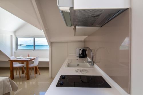 圣马丁岛Sweet Home SXM Baie Nettlé Pieds dans l'eau的厨房配有水槽和炉灶 顶部烤箱