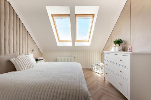 什切齐内克Gold Apartment Szczecinek的卧室配有一张白色大床和天窗
