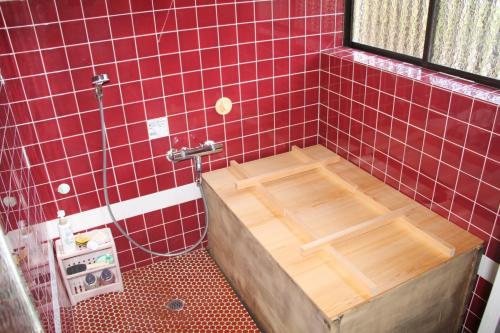下吕市Minpaku Taki - Vacation STAY 12840的浴室内铺有红色瓷砖的淋浴和木浴缸