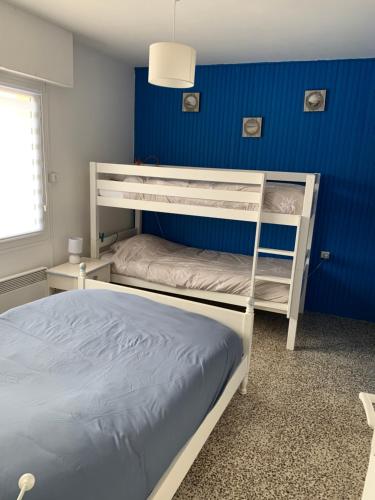 马翁普拉日堡Petite escapade à la Picardière的一间卧室设有两张双层床和蓝色的墙壁