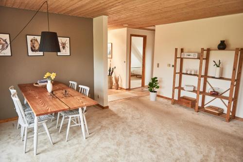 海耶斯Stylish vacation home - close to sea and nature的一间带木桌和椅子的用餐室