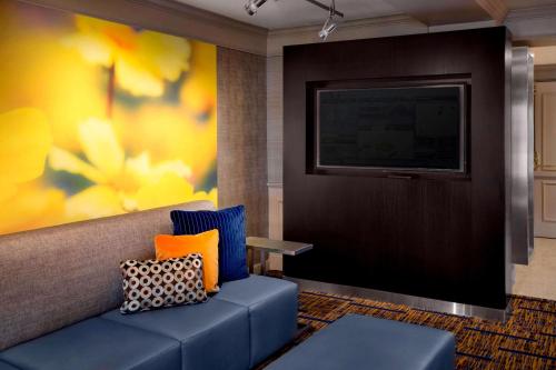 丹弗斯波士顿丹弗斯万怡酒店的客厅配有蓝色的沙发和电视