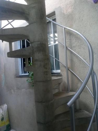 福塔莱萨Kitnet mobiliado, confortável e bem localizado.的螺旋楼梯,位于一栋带窗户的建筑内