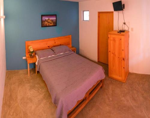 伊察Samay77 Ica的一间卧室配有一张大床和一个木制梳妆台