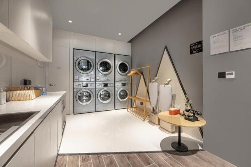 胶州青岛胶东国际机场亚朵酒店的洗衣房配有4台洗衣机和烘干机