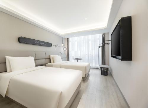 青岛青岛国际会展中心轻居酒店的酒店客房设有两张床和一台平面电视。