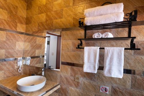 库斯科Hotel Hacienda Cusco Centro Historico的墙上设有带水槽和毛巾的浴室