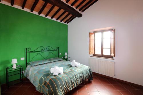 丘西Il casale di Sandra的绿色卧室设有床和窗户