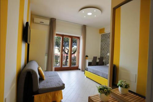 索伦托Guest House Le Tre Isole Sorrento的客房设有床、沙发和镜子