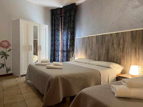 拉齐塞Hotel Renata的一间客房配有两张床和两张带毛巾的桌子。