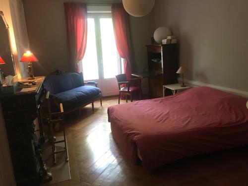 里昂Berges du Rhône/ Chambre avec balcon的一间卧室配有一张床、一张桌子和一把椅子
