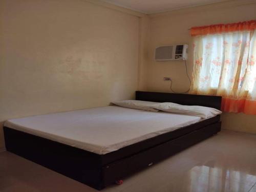 美岸Dannykaela Transient House的一间小卧室,配有一张带窗户的床
