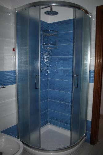 伊斯基亚赛索塔酒店的浴室里设有玻璃门淋浴
