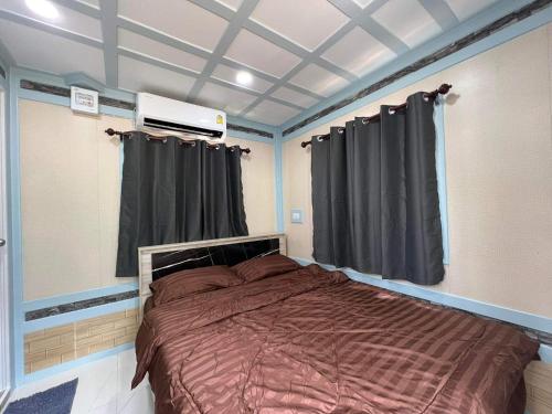 Ban Huai Haiภูผาม่านห่มดาวแคมป์的一间卧室配有一张大床和黑色窗帘