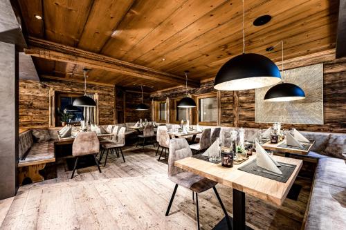 瓦格赖恩ALMMONTE PRÄCLARUM SUITES Design Hotel的餐厅拥有木墙和桌椅