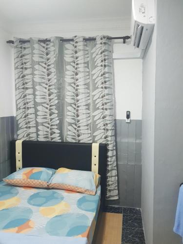 拉布安Orchid Roomstay的一间卧室配有床和窗帘