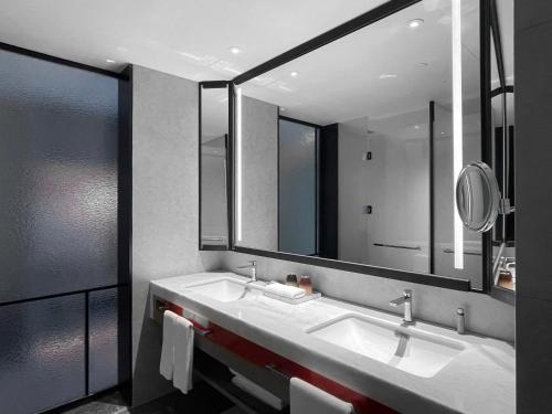 北京北京世纪金源大饭店的一间带两个盥洗盆和大镜子的浴室