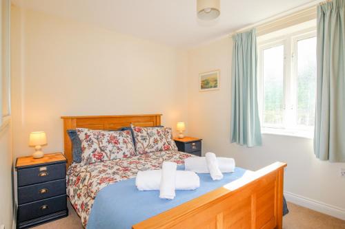 科夫堡Corfe Lodge的一间卧室配有带毛巾的床