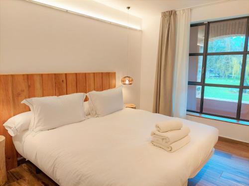 佩雷拉达HOTEL MAS ARET的卧室配有白色床和毛巾