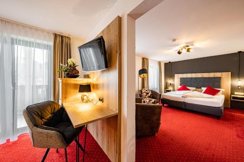 格拉绍Berghotel & Chalets Adersberg的酒店客房,配有床和电视