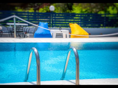 普利瑙港湾Thassian Riviera Hotel的一个带蓝色水和蓝色椅子的游泳池