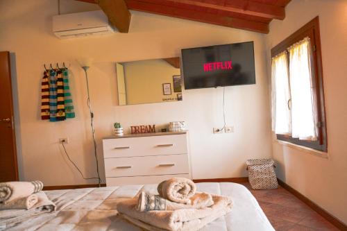 明乔河畔的瓦雷奇奥Il Paiolo Magico的卧室配有一张床铺,墙上配有电视