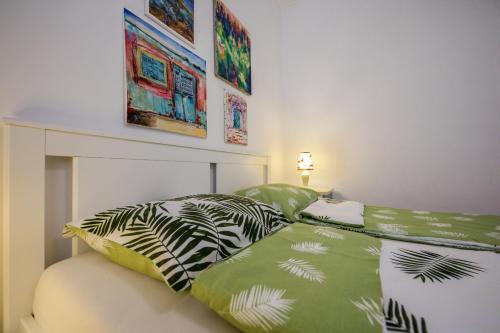 杜布罗夫尼克托哈公寓的一间卧室配有一张带绿色和白色床单的床