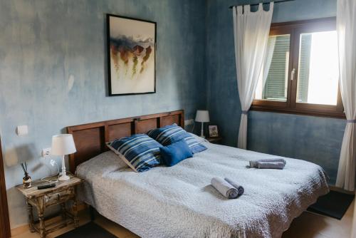 森瑟勒斯Villa Beatrice的一间卧室配有一张蓝色墙壁的床和一扇窗户