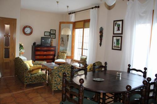 埃尔切德拉谢拉Casa Rural Puerta de la Iglesia的客厅配有木桌和椅子
